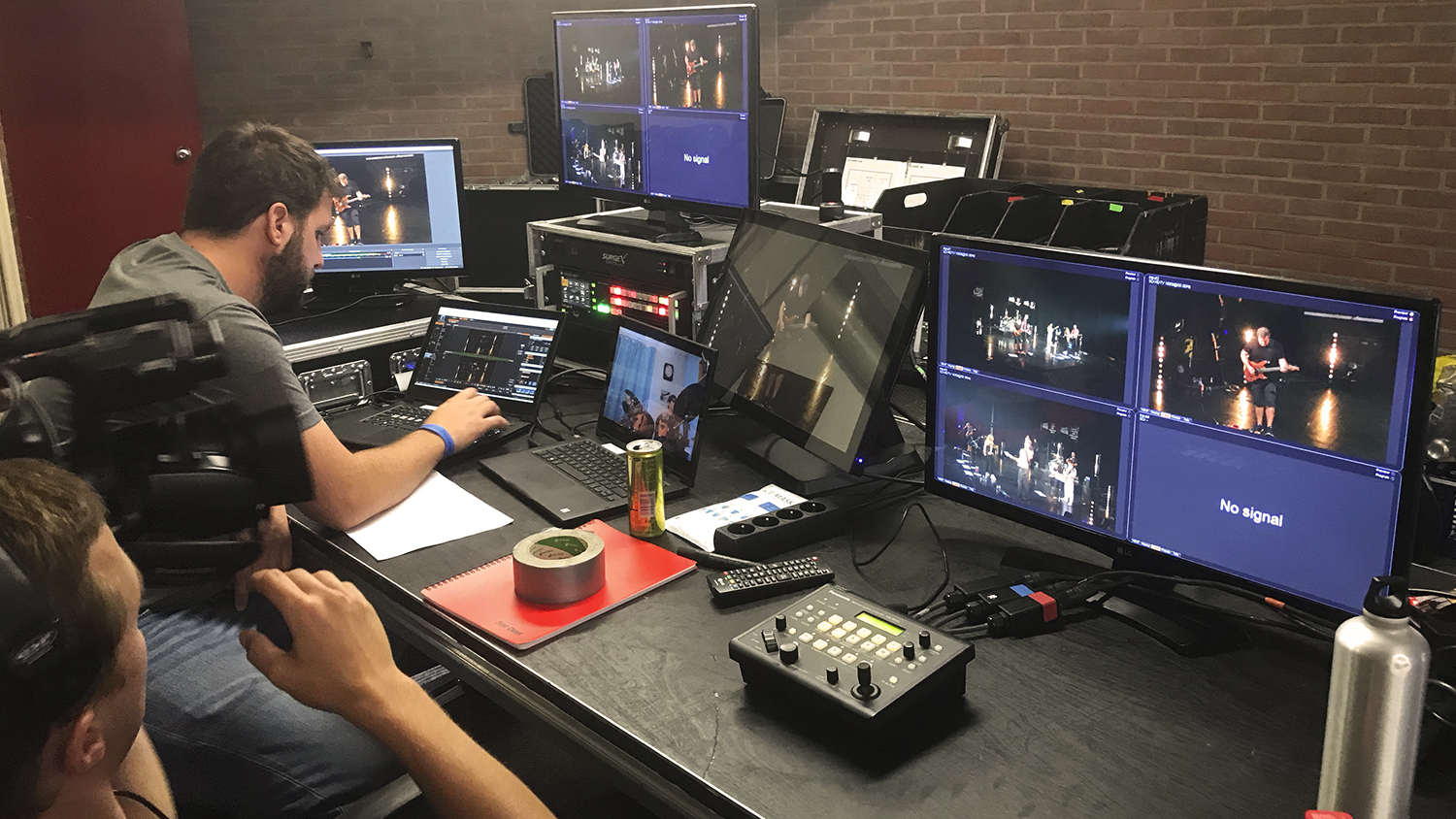 Deux régisseurs derrières des ordinateurs pour prépaper un concert