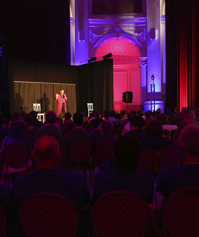 Monsieur Loyal sur scène devant un public dans une église lors de l'évènement Clownmania