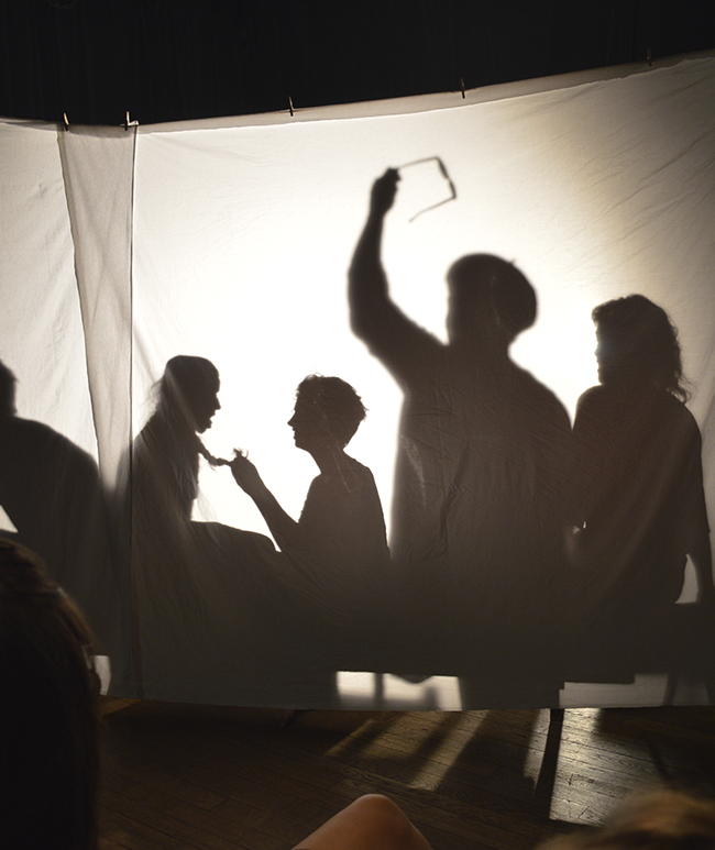 Les ombres des comédiens projetés sur un drap lors d'une pièce de théâtre